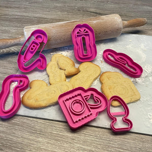 Koekjes en roze bakvormpjes met de vormen van verschillende seksspeeltjes