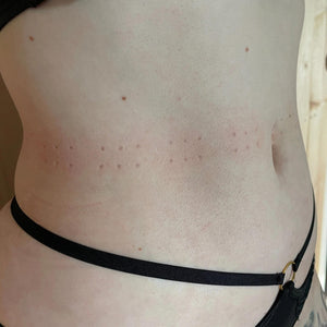 De afdrukken op de middel van een persoon, afkomstig van een lederen band met spikes voor BDSM