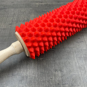 Een deegroller met spikes voor BDSM in rood