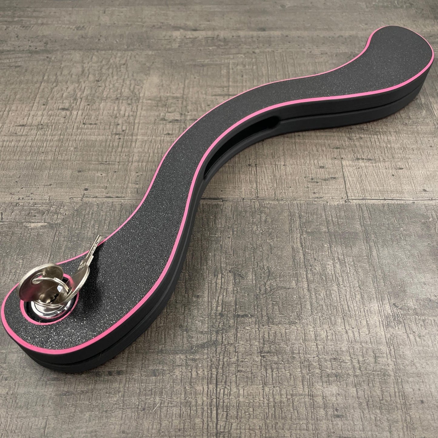 Een BDSM humbler met slot in het zwart met roze accenten