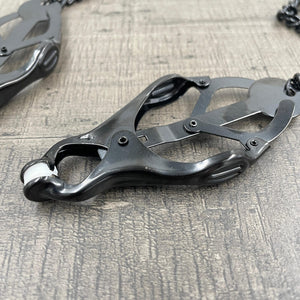 Een set zwarte clover-clamps tepelklemmen met een ketting