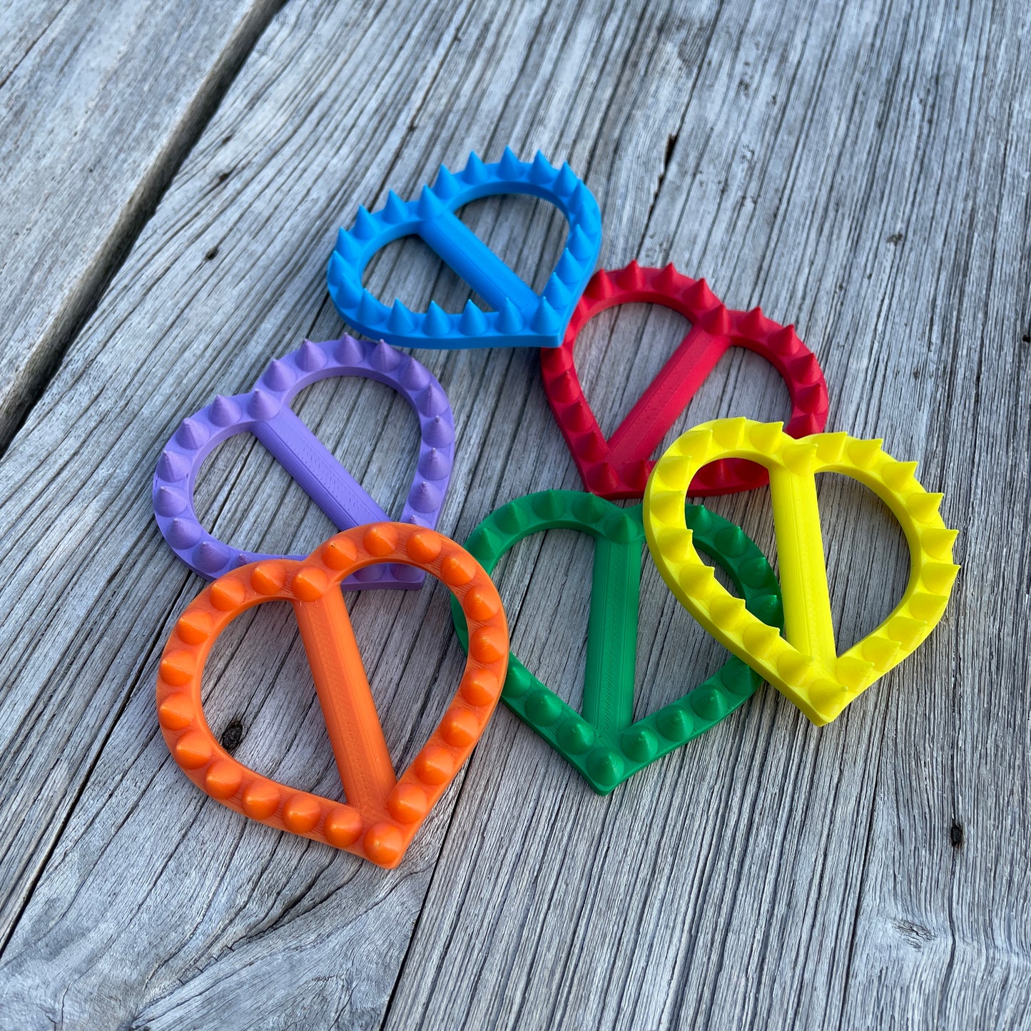 Zes hartvormige shibari rope spikes in de kleuren van de regenboog