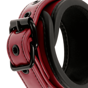 Detail shot of the buckle on a BDSM ankle cuffs made from vegan leather in red and black colour