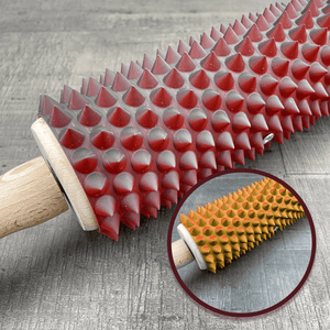 Een deegroller met spikes voor BDSM met een kleurverloop van zwart, rood en geel