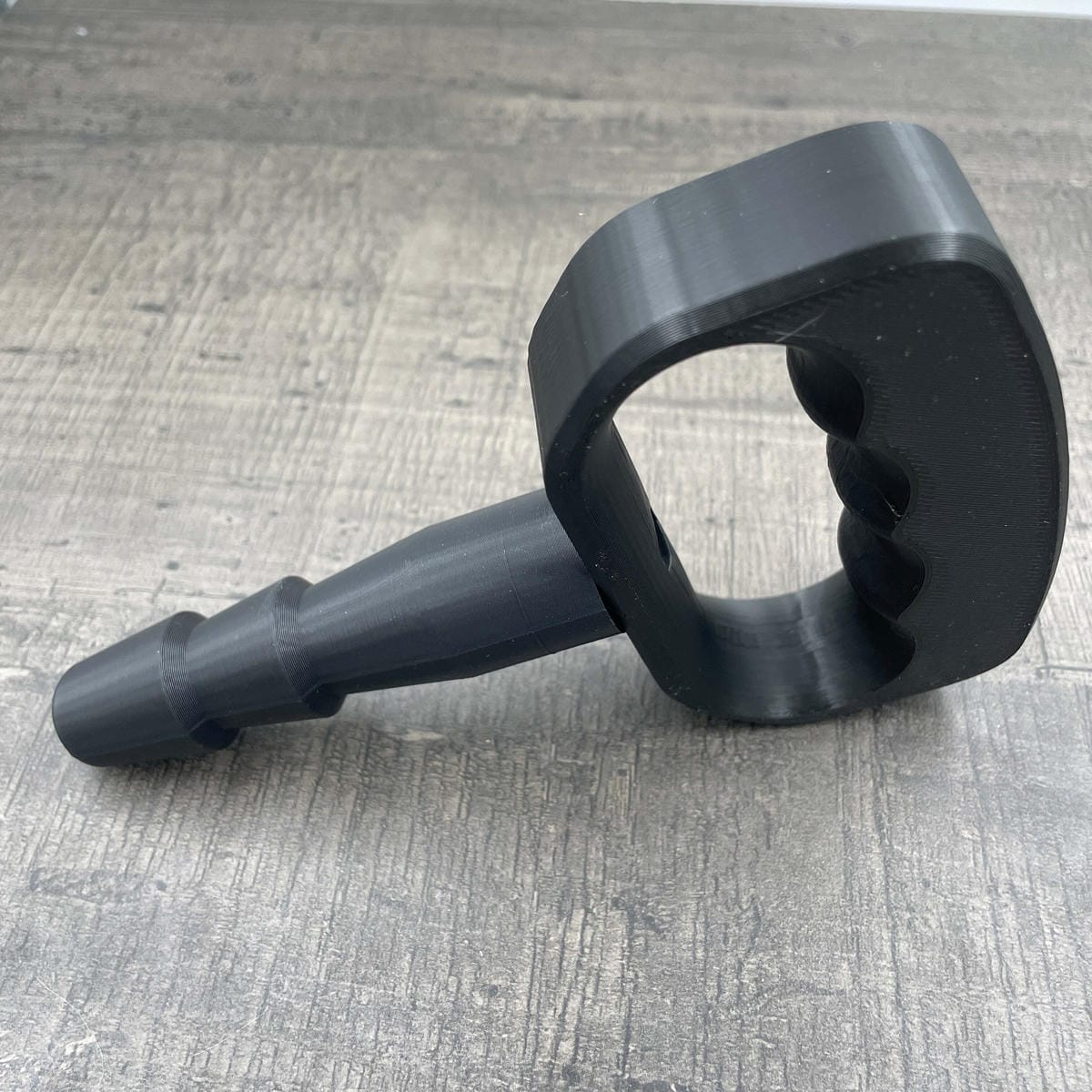 Een adapter voor vac-u-lock seks toys met een zwarte handgreep.