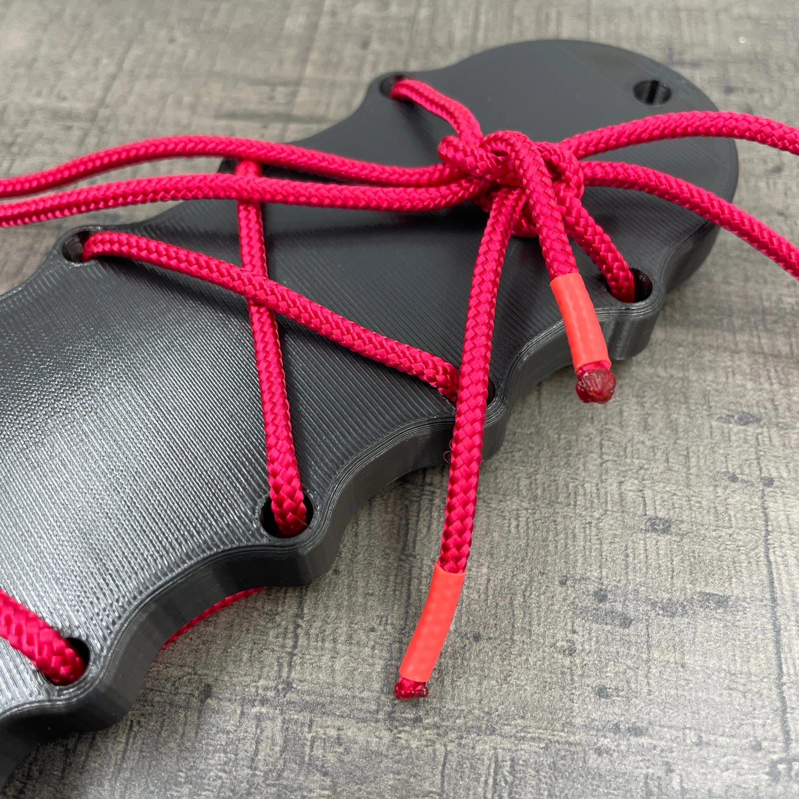 Een BDSM CBT plankje met rood touw