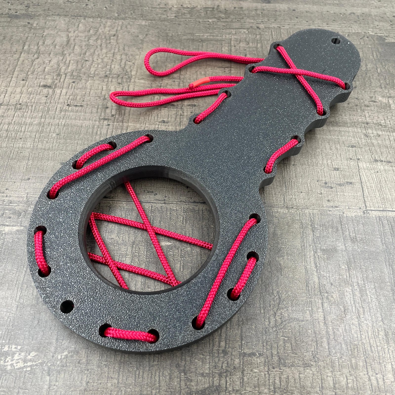 Een BDSM CBT plankje met rood touw