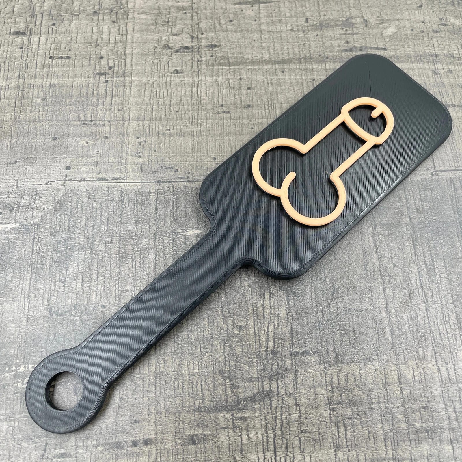 Een kleine BDSM paddle met de afbeelding van een penis