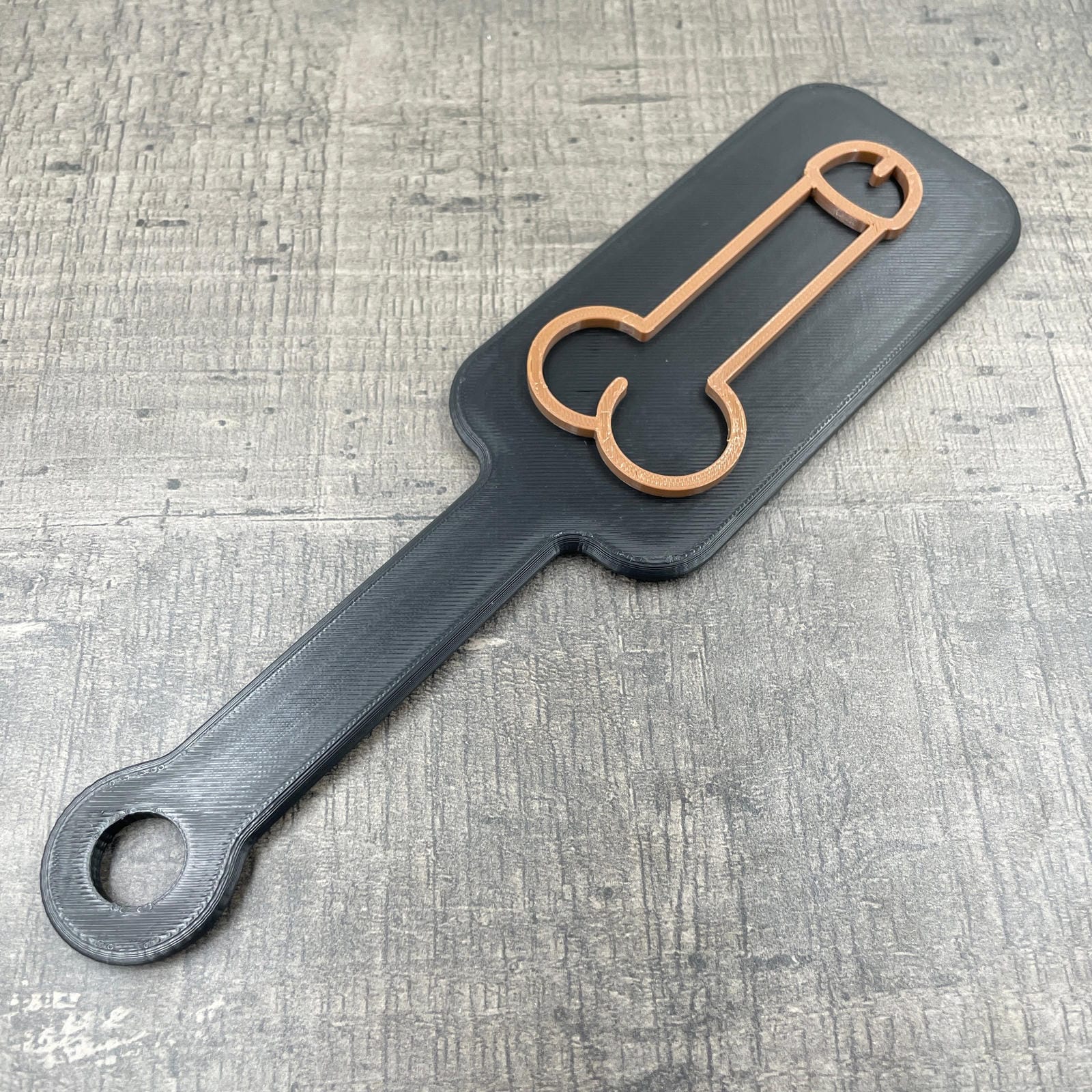 Een kleine BDSM paddle met de afbeelding van een penis