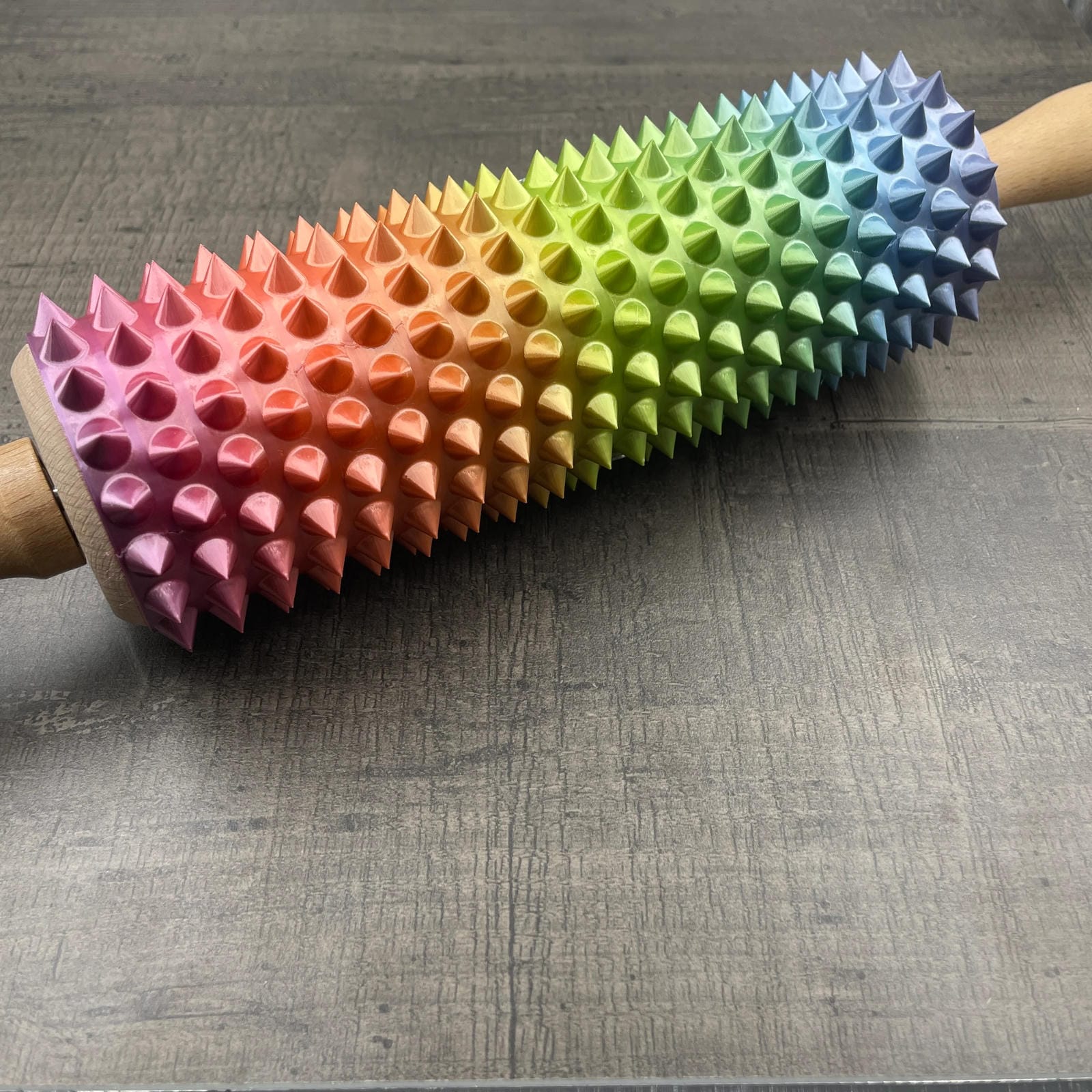 Een deegroller met spikes voor BDSM in regenboog kleur
