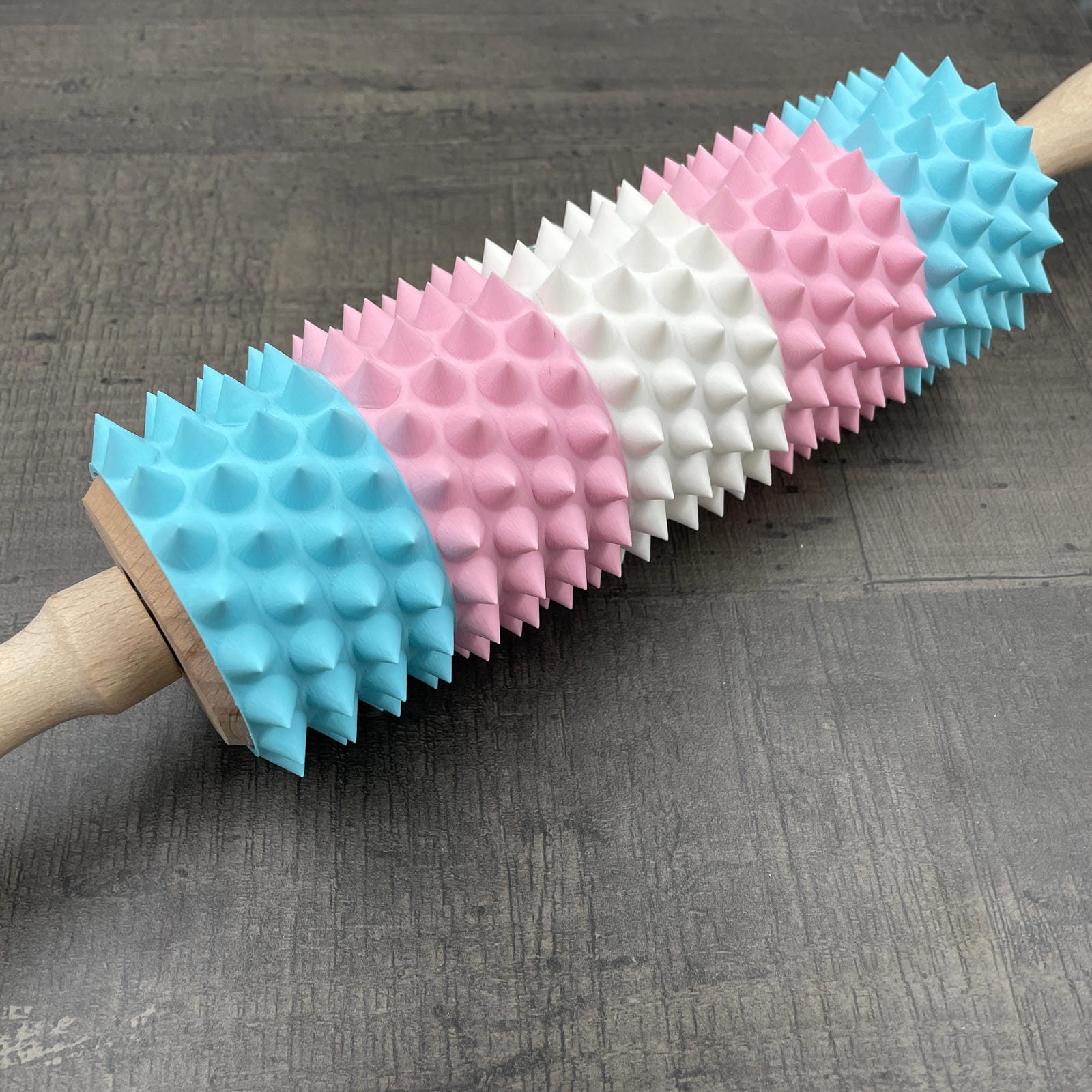 Een deegroller met spikes voor BDSM in de kleuren van de trans-vlag