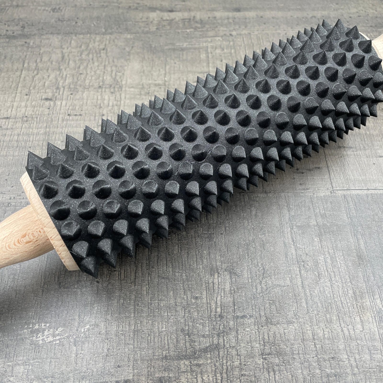 Een deegroller met spikes voor BDSM in de kleur zwart met glitter
