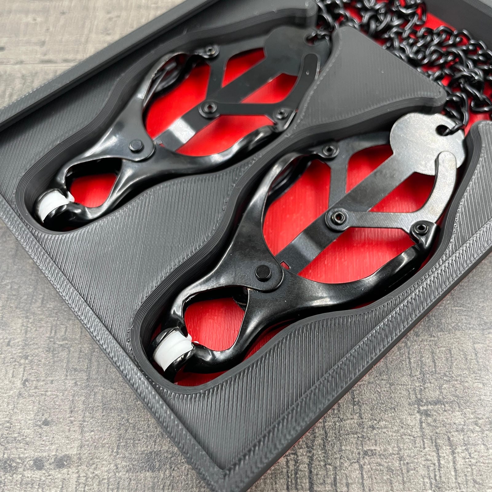 Een set zwarte tepelklemmen in een doosje