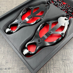 Een set zwarte tepelklemmen in een doosje