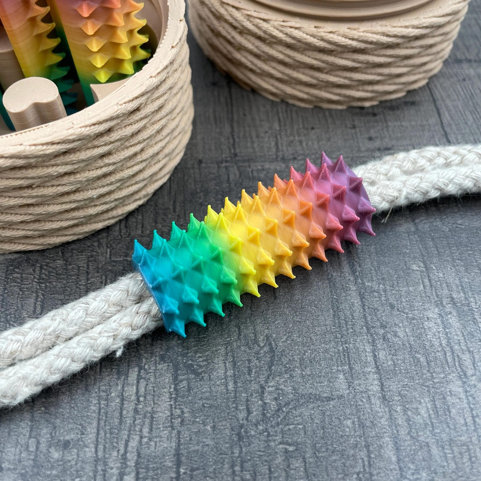Een shibari rope spike in regenboogkleuren van 3DSM op een stuk touw