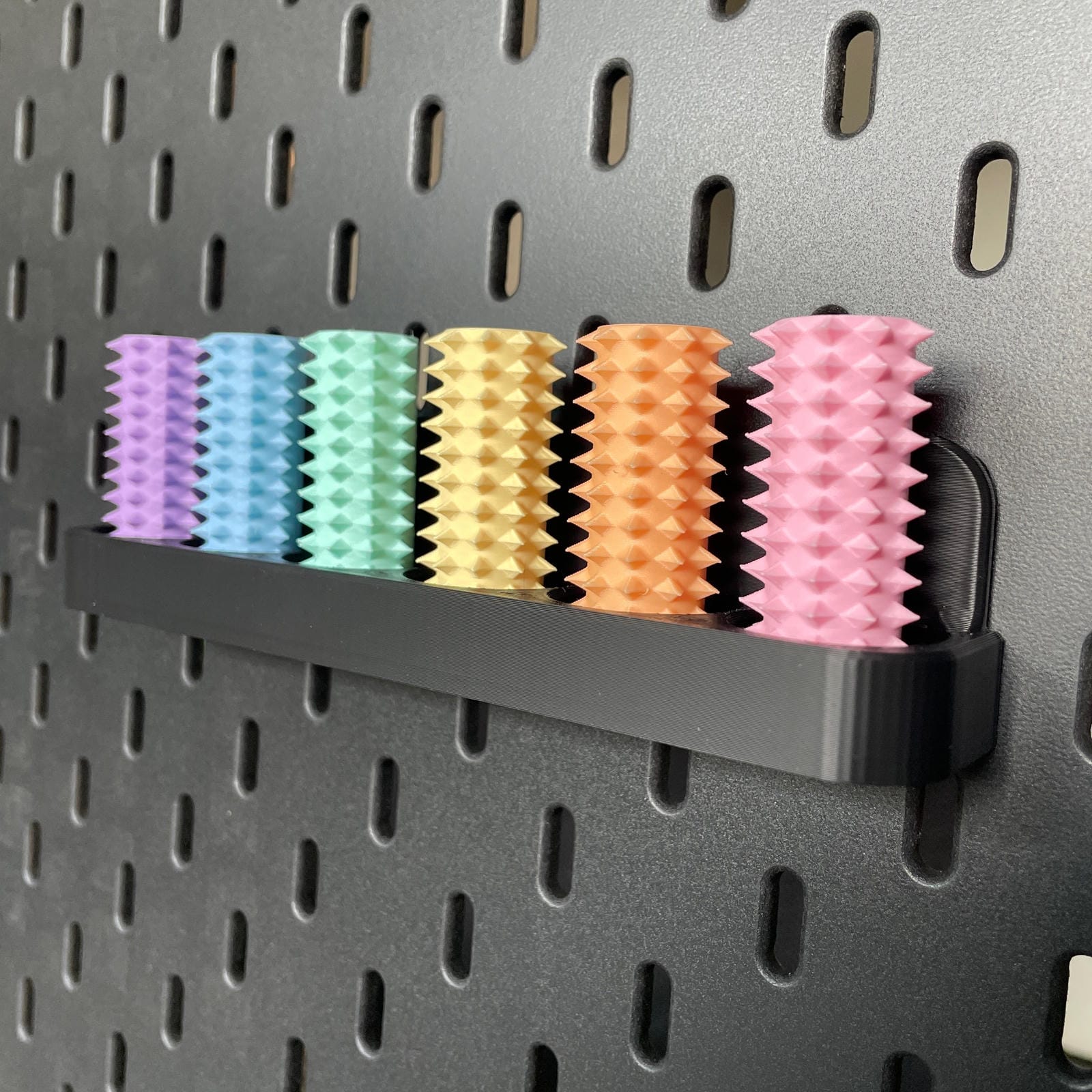 Een doosje met zes shibari rope spikes in regenboog kleuren voor de Ikea Skadis