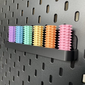 Een doosje met zes shibari rope spikes in regenboog kleuren voor de Ikea Skadis