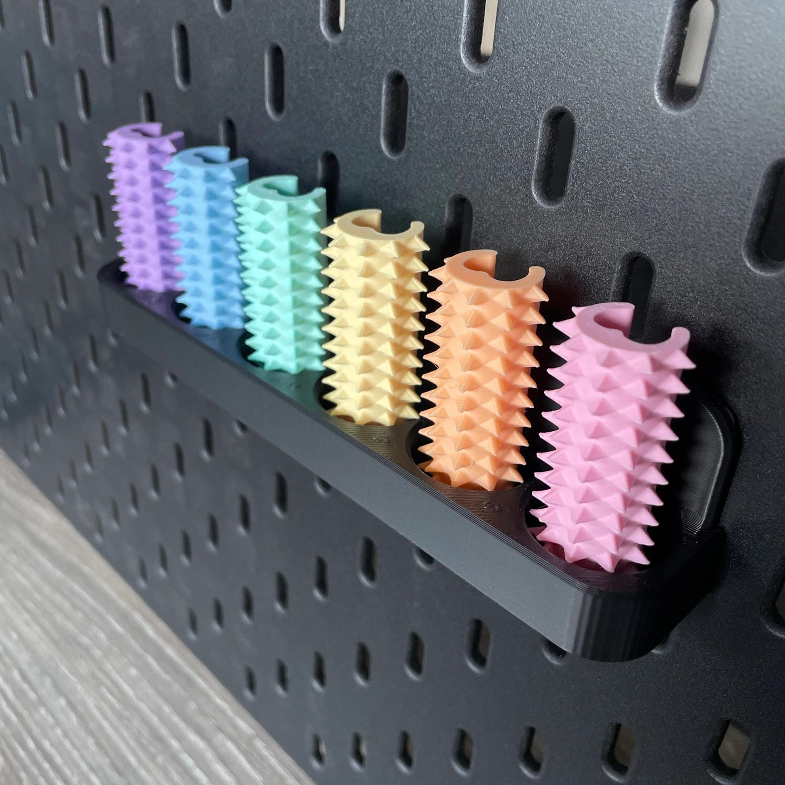 Een doosje met zes shibari rope spikes in regenboog kleuren voor de Ikea Skadis