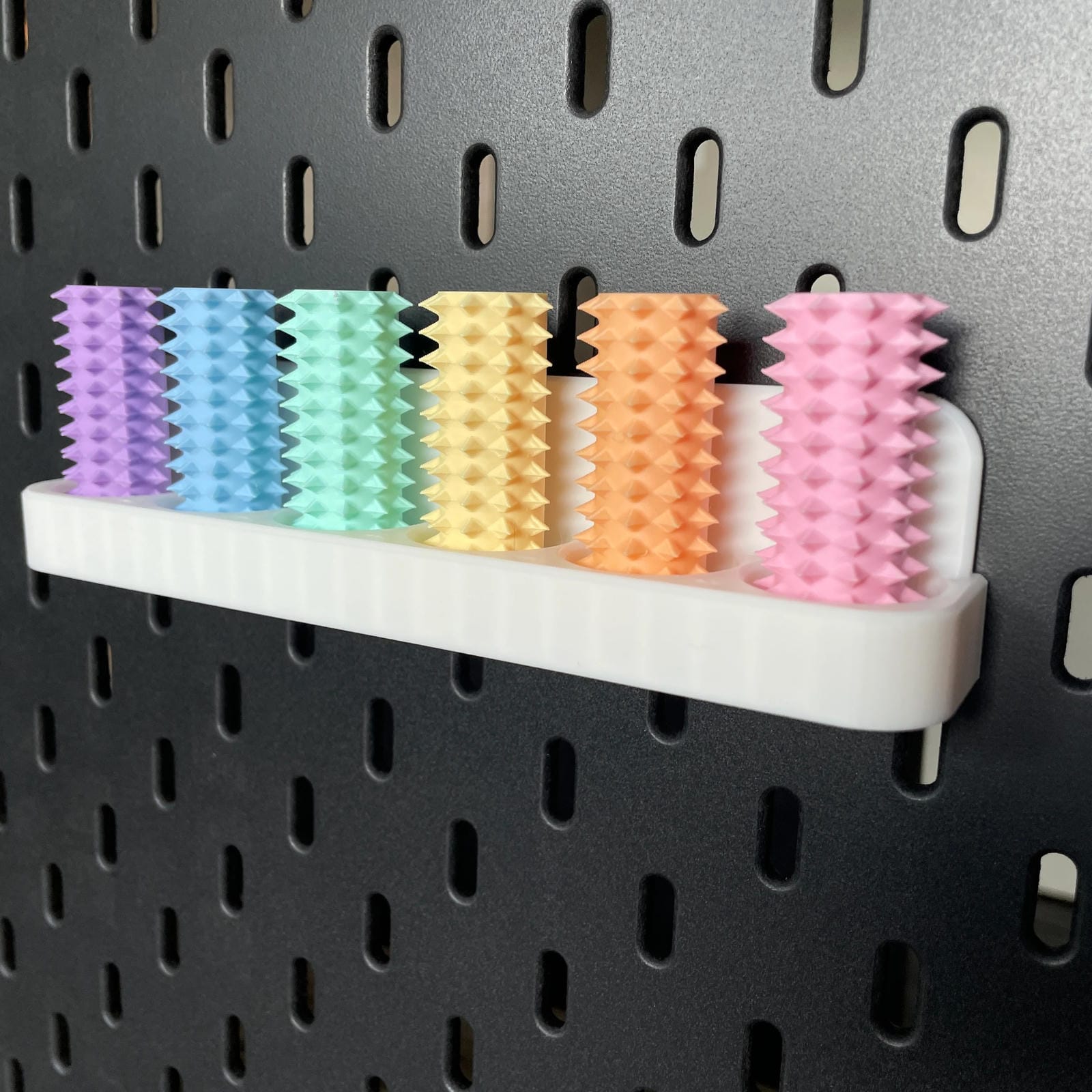 Een doosje met zes shibari rope spikes in regenboog kleuren voor de Ikea Skadis